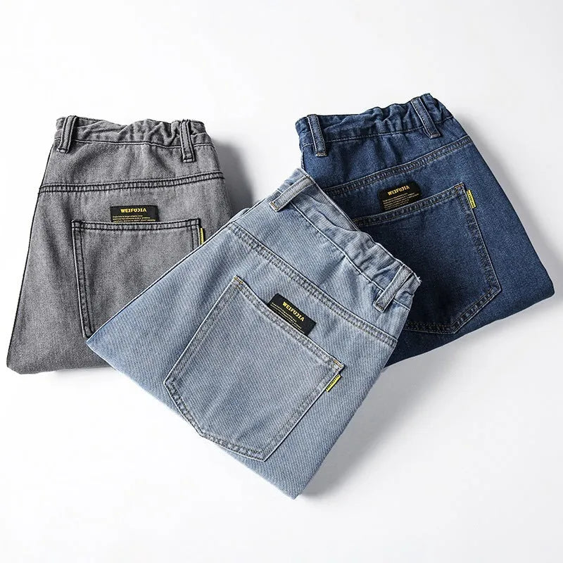 Men's loose straight-cut cotton jeans in dark blue, shown on a man in a casual setting.