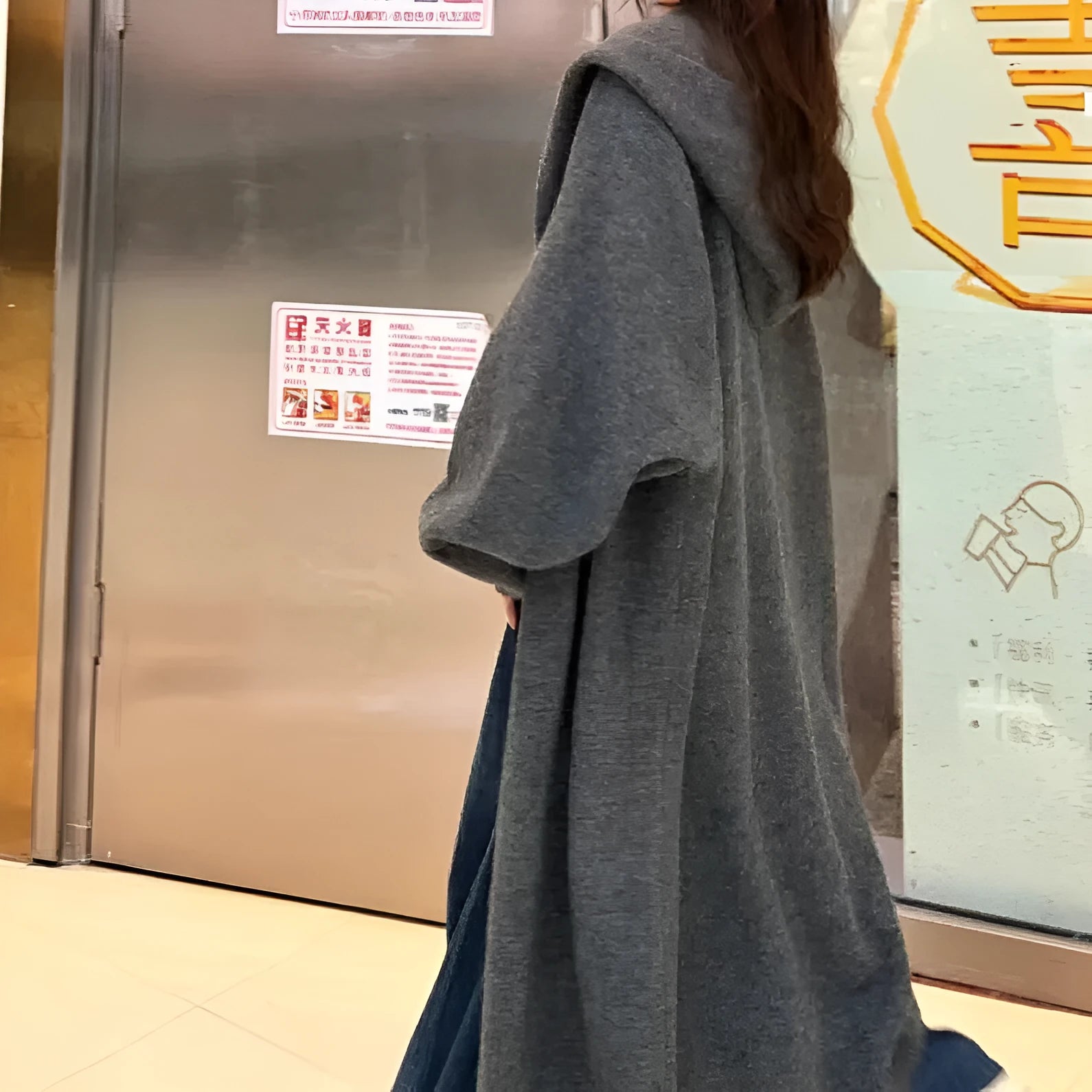 Women's long hooded knitted cardigan in loose fit, shown in oatmeal colour.