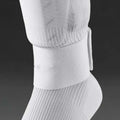 Rubber football shin guard belt in multiple colours securing protective pad on athlete's leg