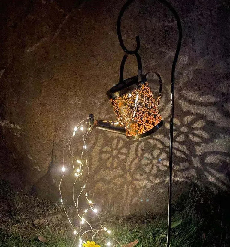 Solar watering can garden lamp with hollow-out iron shower body and 36 warm white LED lights on copper wire, installed in grass