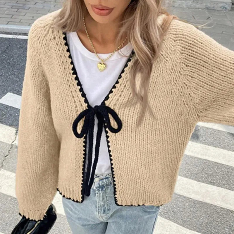 Grey lace-up sweater cardigan with long sleeves and crocheted flower decoration on the front.