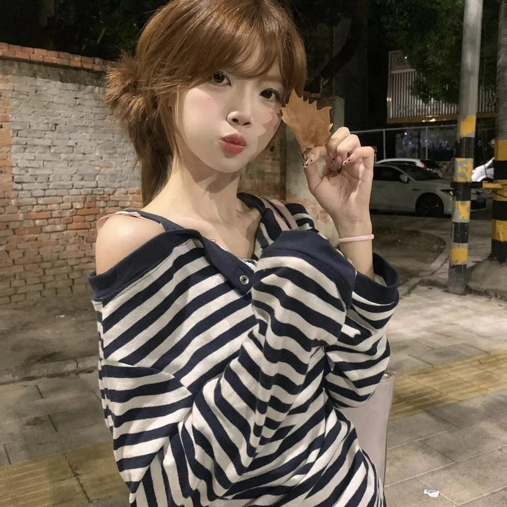 Dark blue women's long-sleeved t-shirt with an oversized fit, showing stripe and embroidery detail on the front.