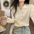 A woman wearing a loose-fit, long-sleeved knitted cardigan in a beige colour, showcasing its drape and cardigan style.