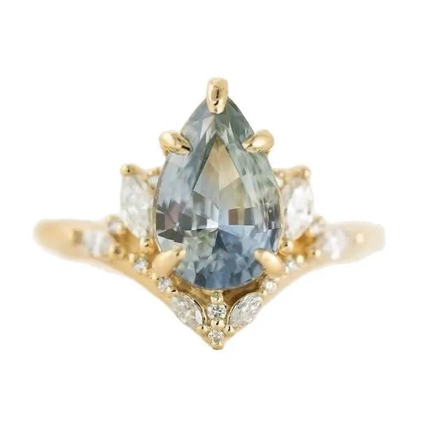 Gold alloy ring with blue crystal diamond inlay and floral design on white background