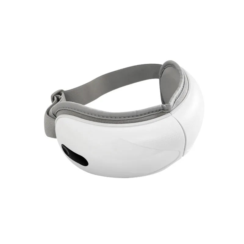 White rechargeable eye massager with airbag massage and hot compress function on a table.