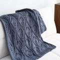 Nordic style knitted acrylic throw blanket 127x152cm in milky white on a sofa