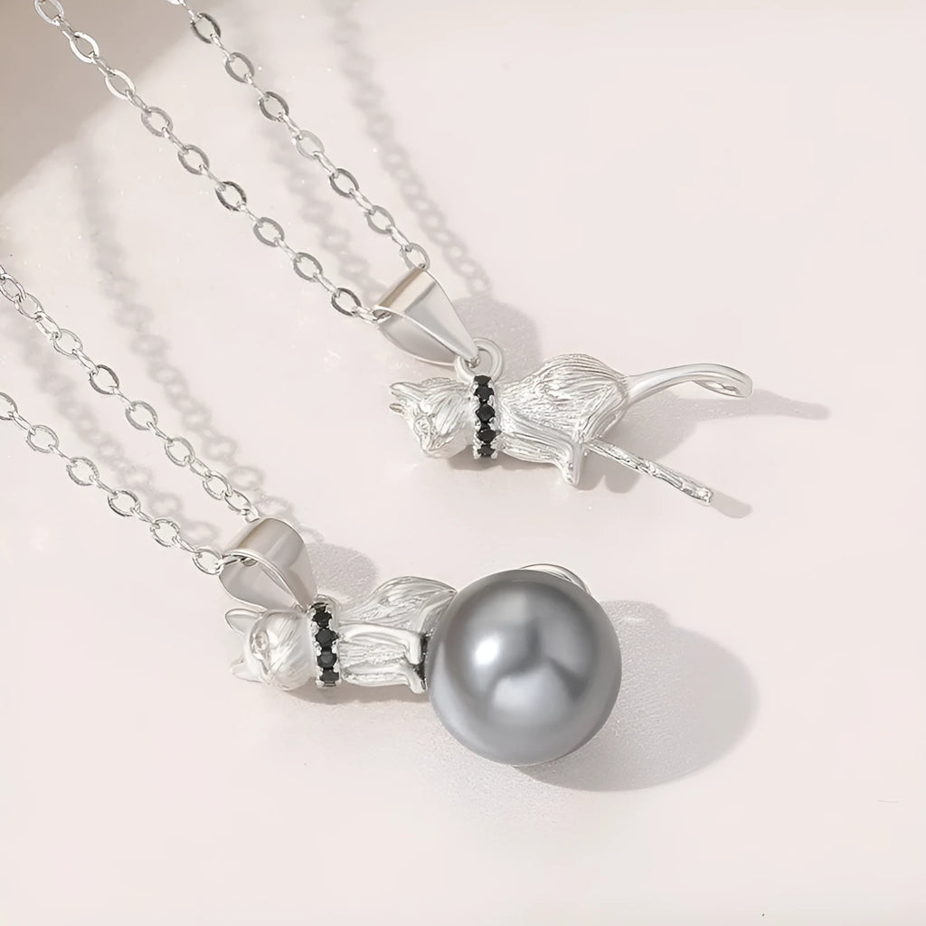 Close-up of a sterling silver cat pendant necklace on a clavicle-length chain, showing the electroplated finish.