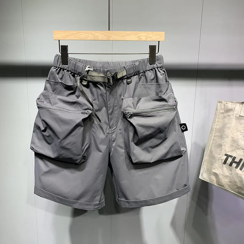 Men's solid black loose-fit work shorts with pockets, shown above the knee.