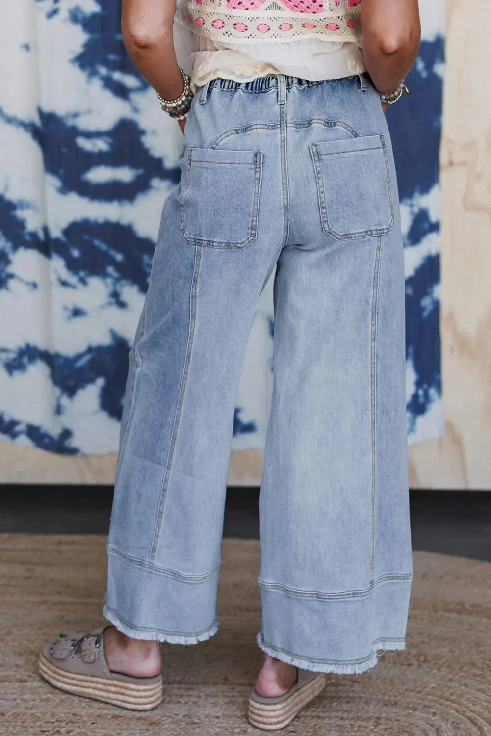 Beau blue wide leg denim pants with elastic drawstring waist and raw hem finish laid flat