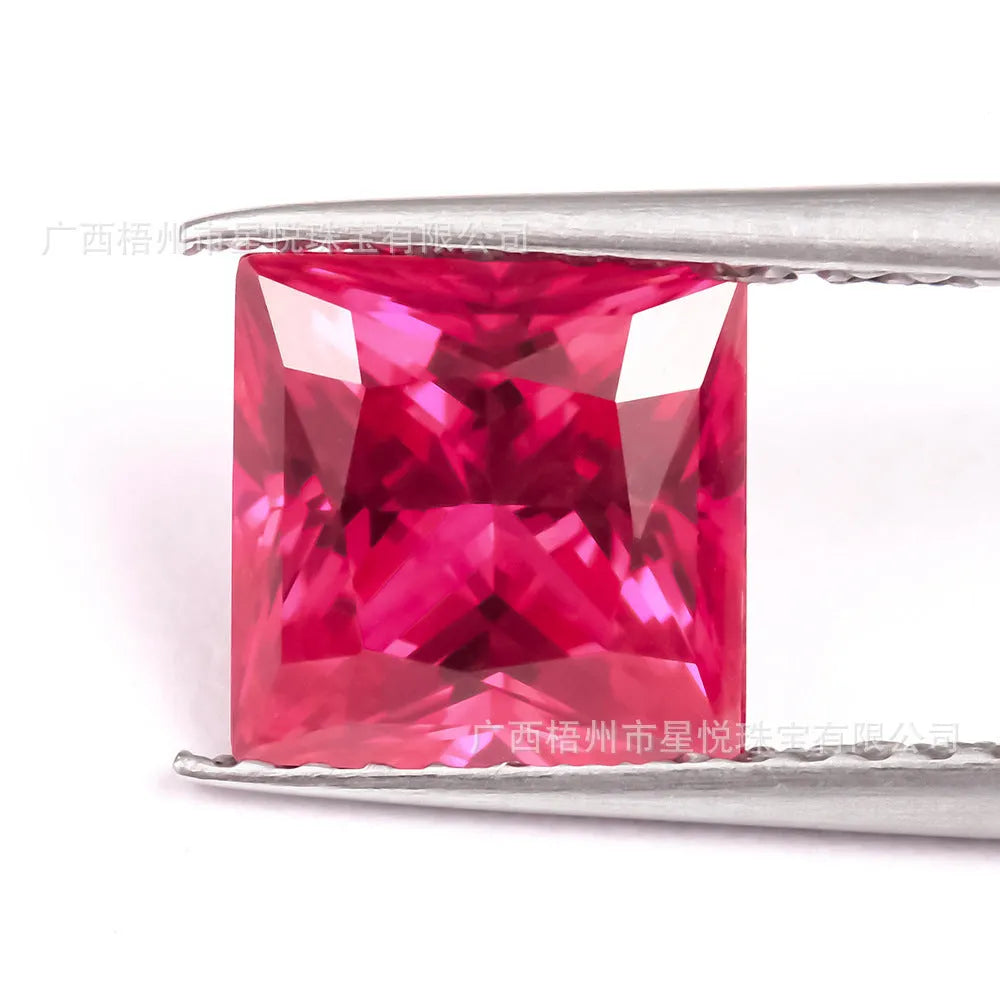 Cultivated ruby gemstone in various cuts including round, princess, oval and pear shapes on white background.
