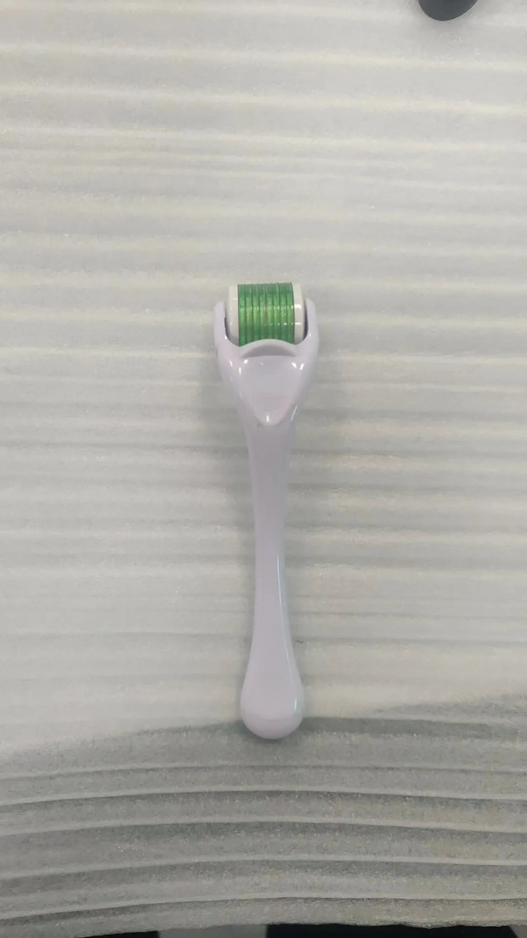 Black handle microneedle roller with purple wheel showing 540 needles, next to white and blue handle options.