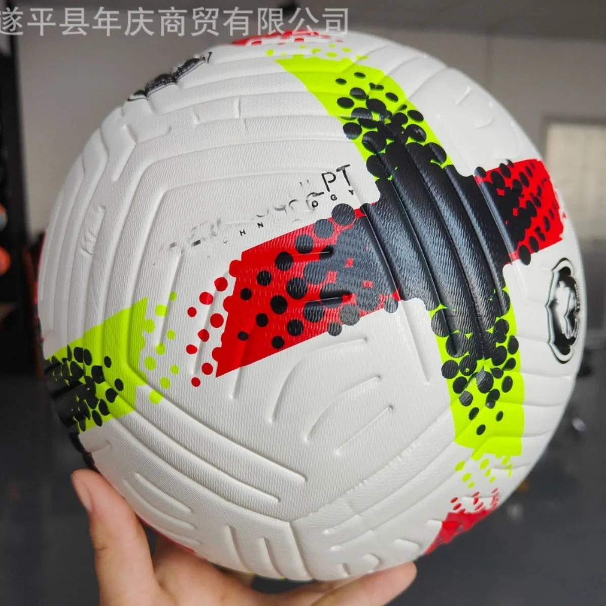 Fluorescent green size 5 PU football with seamless thermal adhesive construction on a pitch.