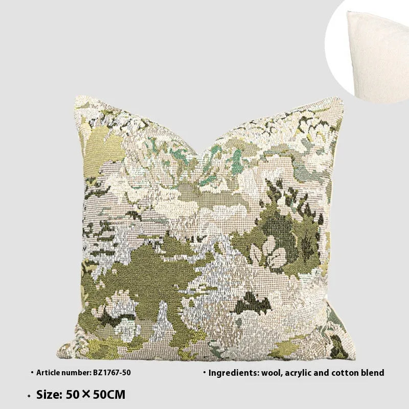 Antique green square pillow with abstract spring flowers pattern on a grey sofa.
