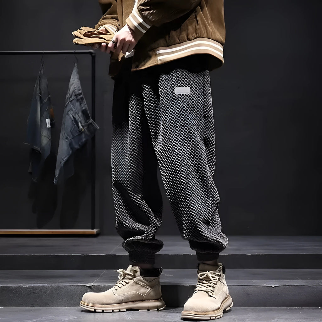 Men's grey ankle-tied straight leg sweatpants laid flat, showing casual sports design.