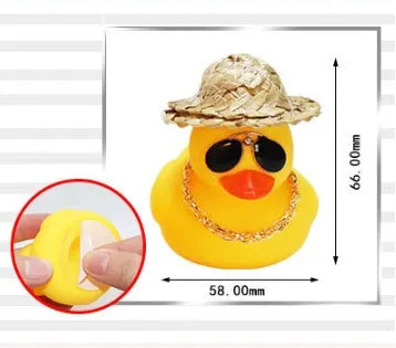 Yellow cartoon duck car ornament wearing a straw hat, with miniature sunglasses accessory.