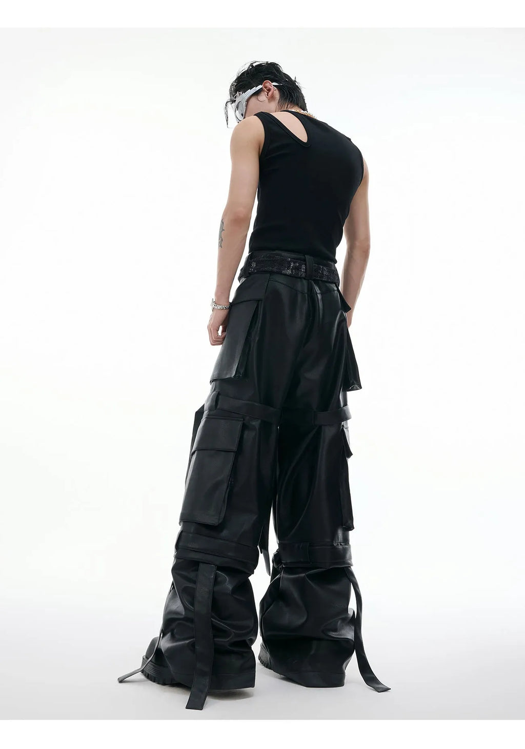Black retro-style loose-fit trousers with multiple pockets, heavy stitching, and ribbon detail on a hanger.