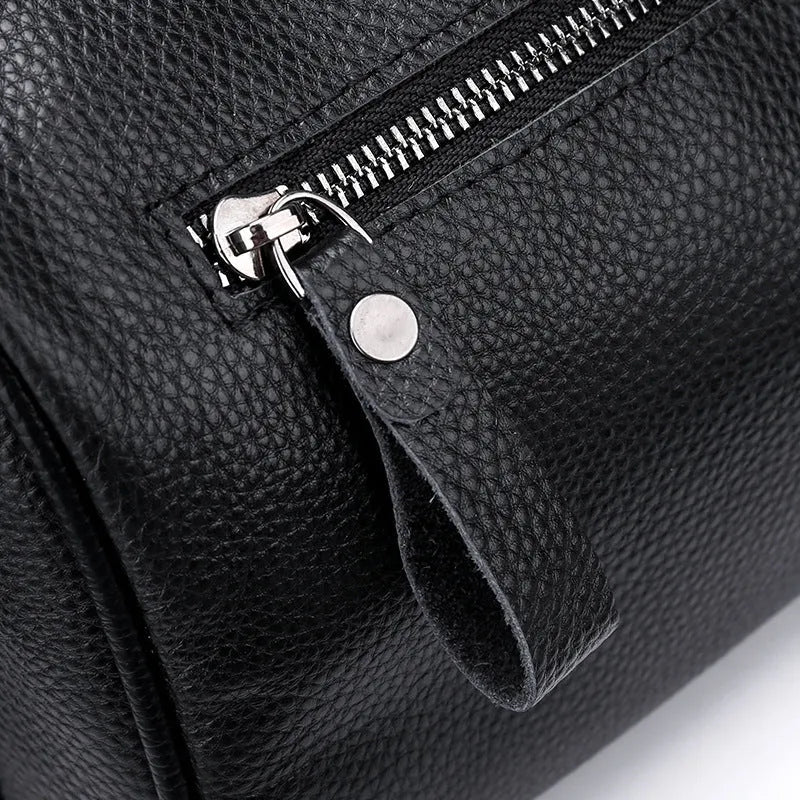 Black genuine leather crossbody bag showing single shoulder strap and structured 24x16x13cm design.
