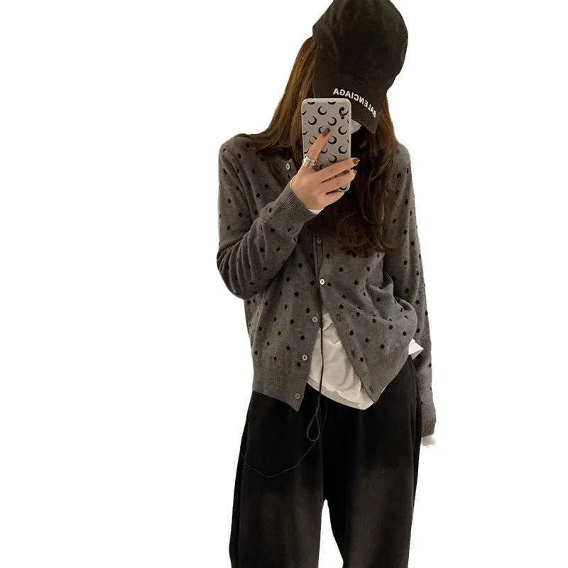 Women's grey dot pattern knitted cardigan with crochet flower detailing on mannequin