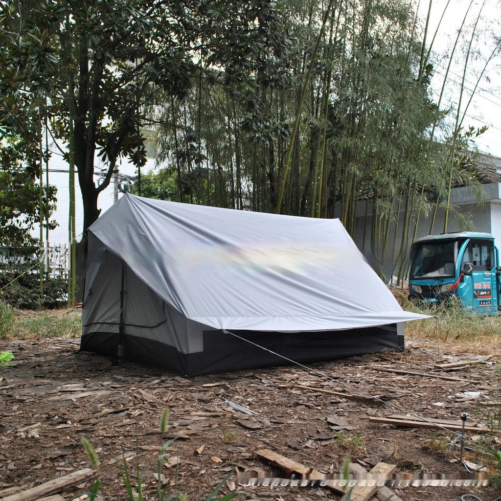 Brown A-line cabin tent pitched using hiking poles with aluminium ground nails and fluorescent wind ropes