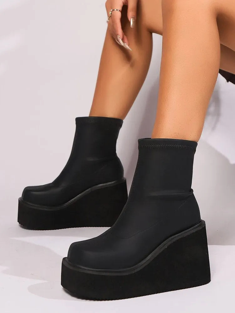 Plus size women's black ankle boots with a wedge heel and waterproof platform sole.