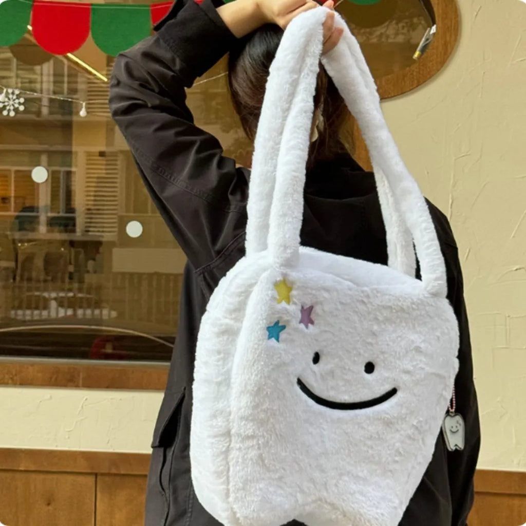 White plush tote bag with cute teeth pattern, showing crossbody strap and zipper closure.