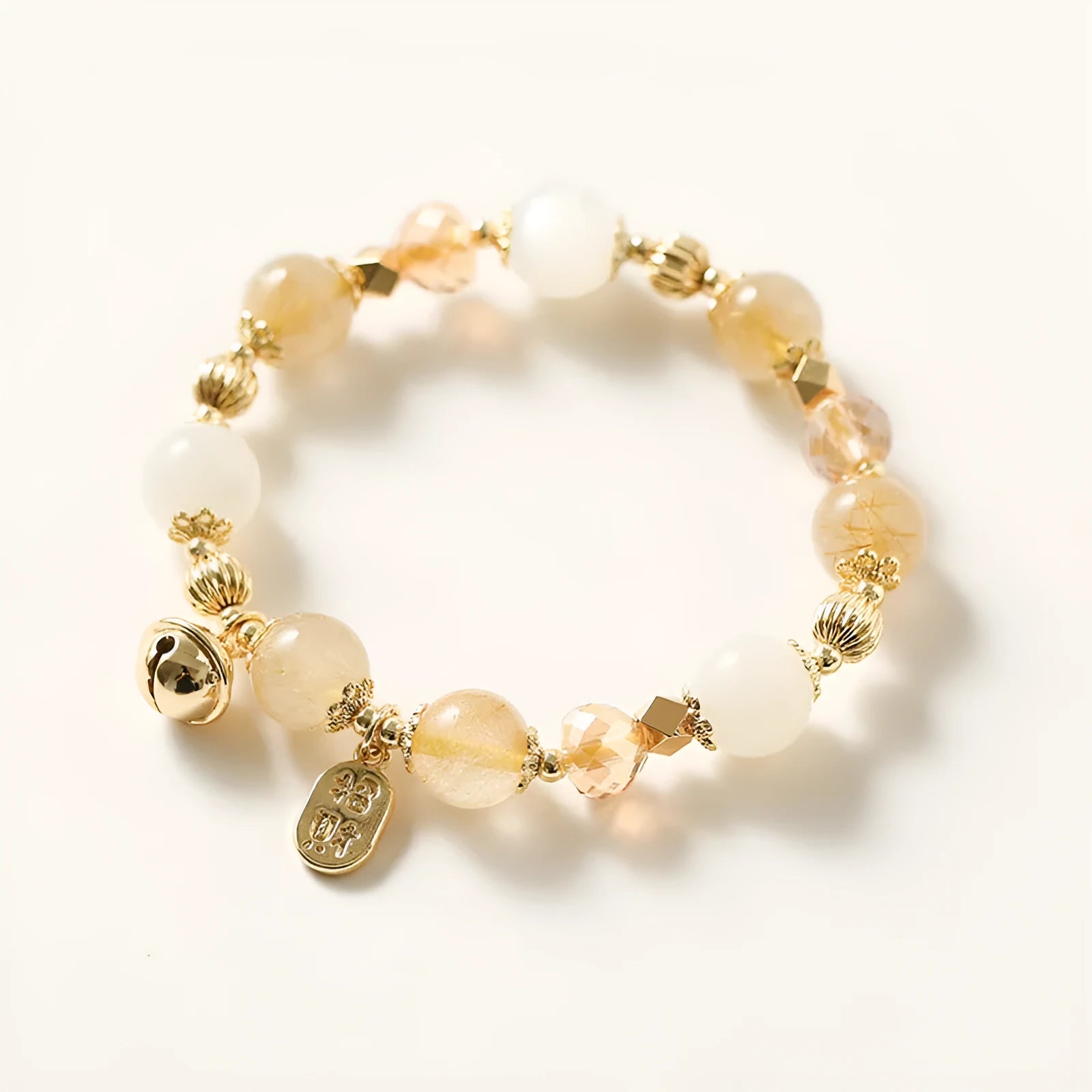 Gold electroplated bracelet with rutilated quartz and a ringing bell charm