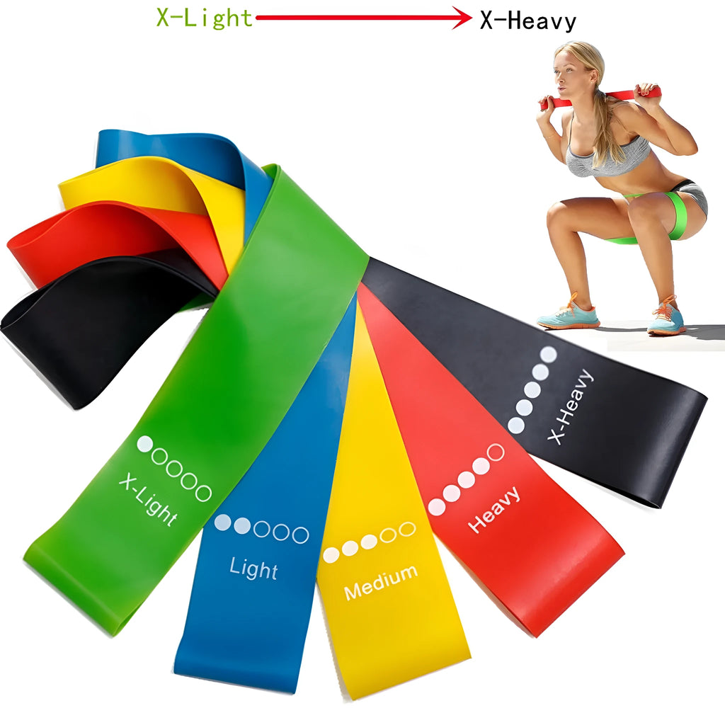 Set of five coloured TPE yoga tension straps for fitness training laid flat showing green, blue, yellow, red, and black.