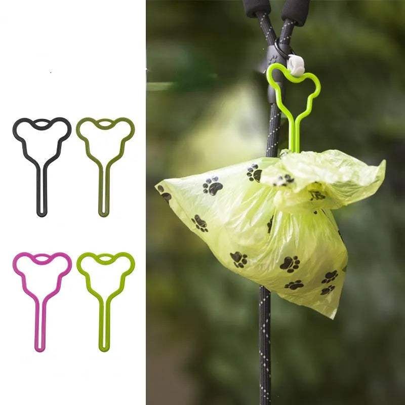 A hands-free dog poop bag holder with a fixed clip and adjustable black Velcro strap, shown attached to a dog lead.
