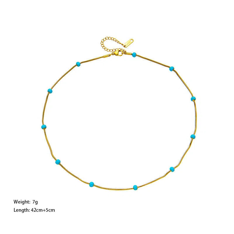 Titanium steel ball drop glaze necklace in green pearl gold, clavicle length, on model