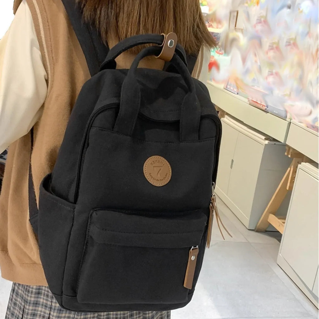 Black retro-style Oxford cloth backpack with curved shoulder straps.