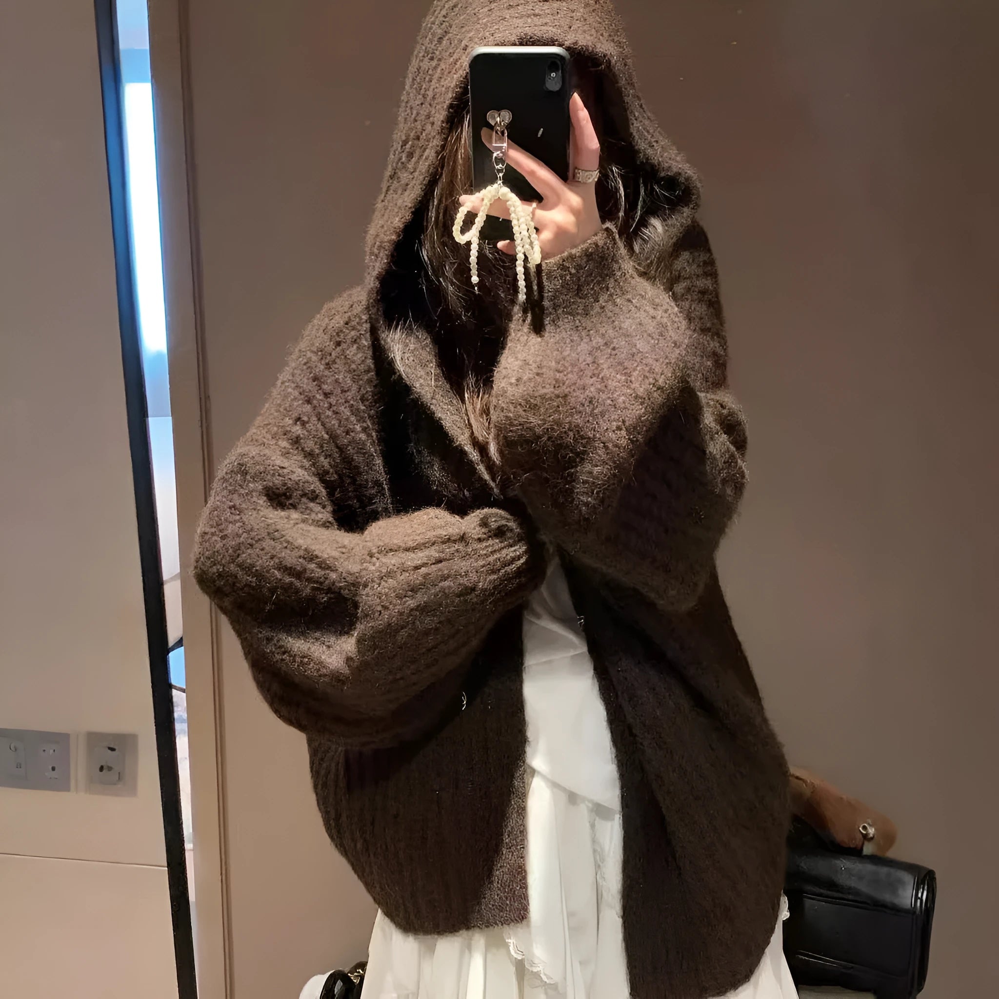 Woman wearing a brown retro-style Maillard hooded cardigan with a thick knit and loose fit.