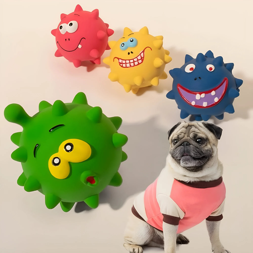 Four colourful natural latex squeaky dog toy balls with cute faces on a blue background.