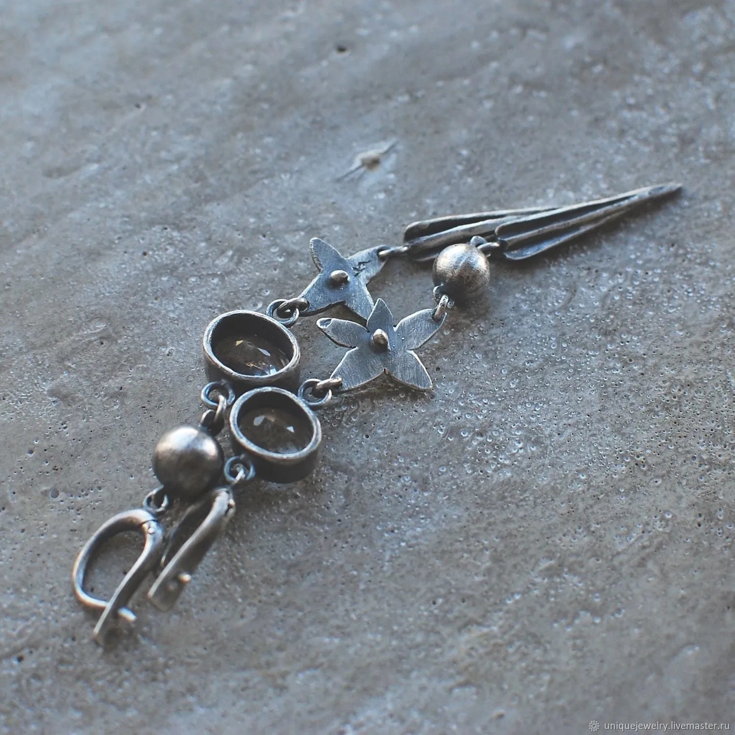 Geometric long pendant earrings with rhinestone drops in antique silver finish.