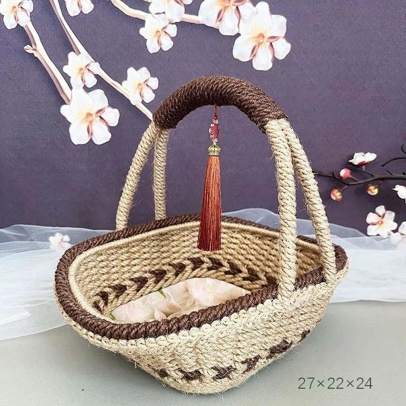 Coffee brown hand-woven straw basket with hemp rope handle, shown next to a small plant for scale.