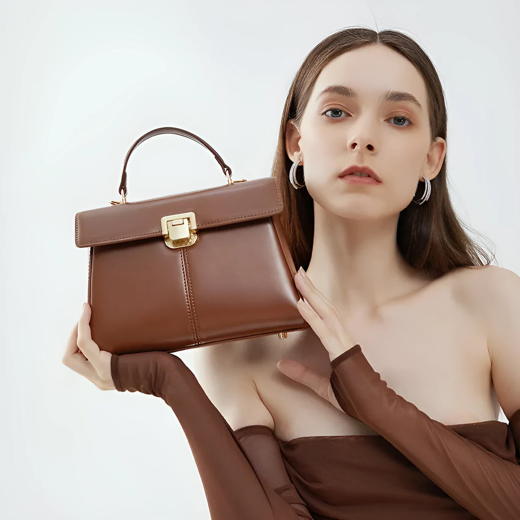 Women's black leather shoulder bag with vachette clasp showing organised interior compartments