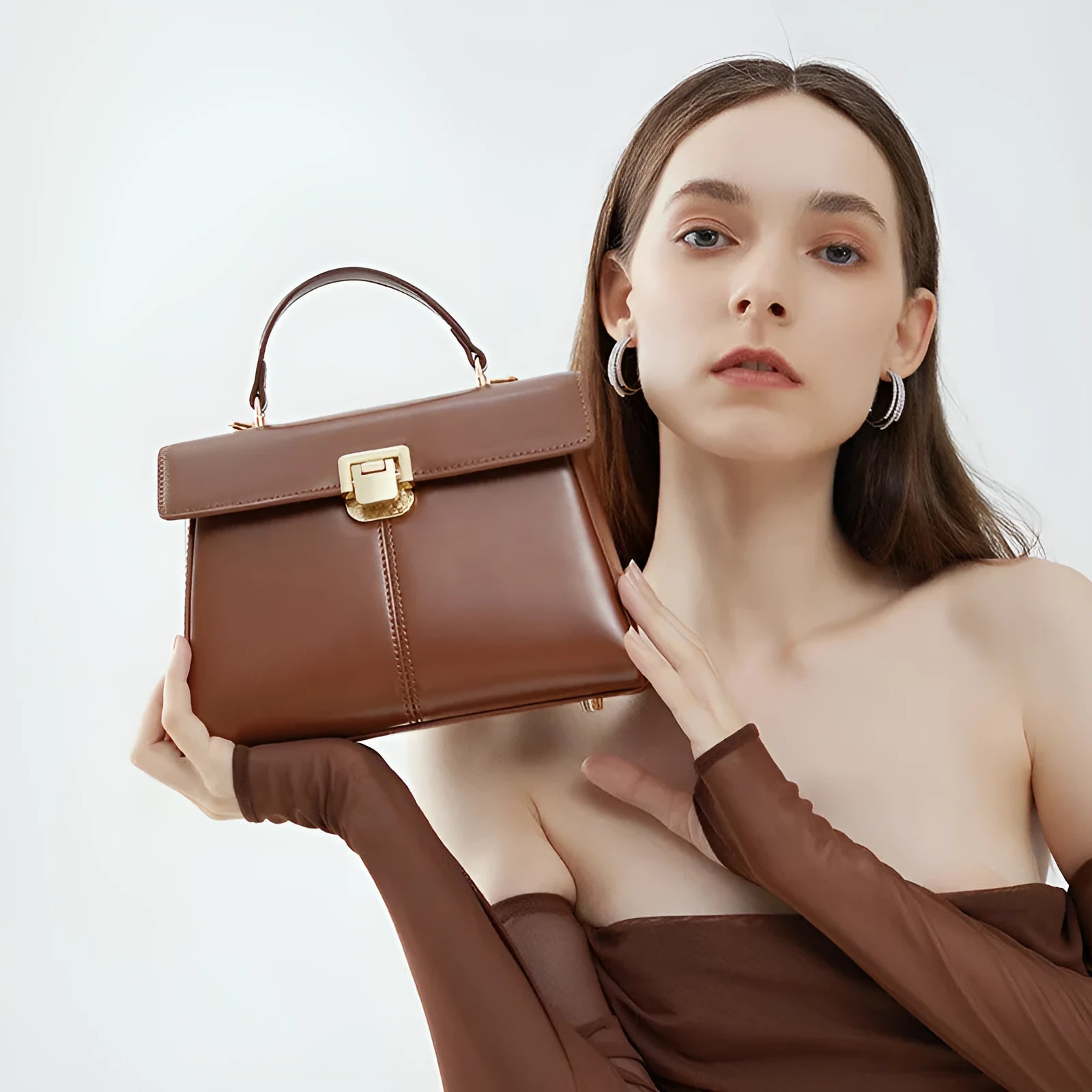 Women's black leather shoulder bag with vachette clasp showing organised interior compartments