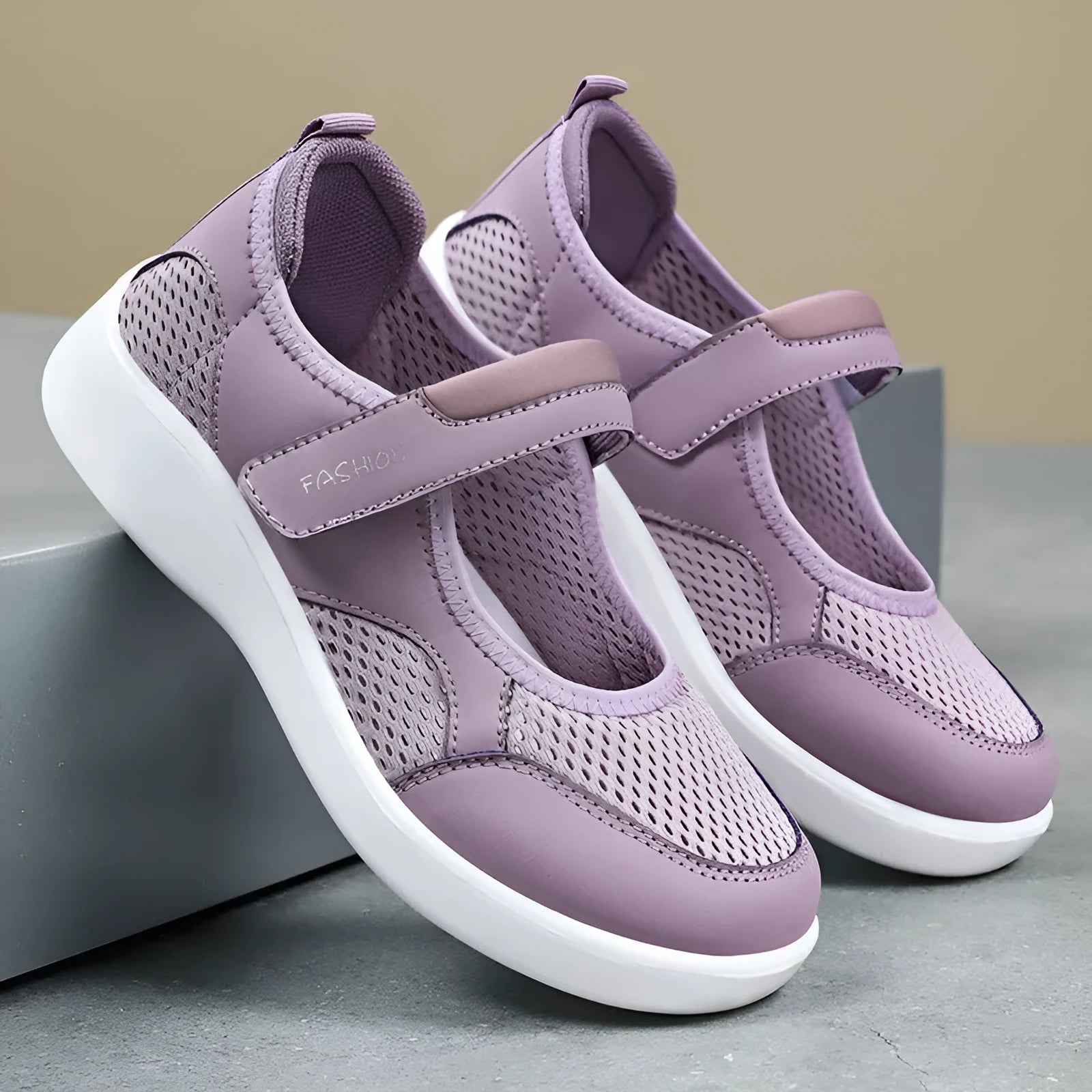 Women's grey breathable mesh slip-on shoe with Velcro strap, flat heel, and round toe.