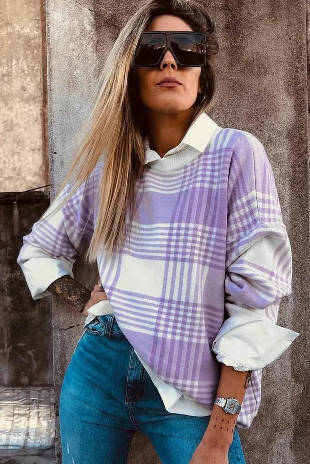 Loose lilac plaid print sweater with long sleeves and ribbed trim on a hanger.
