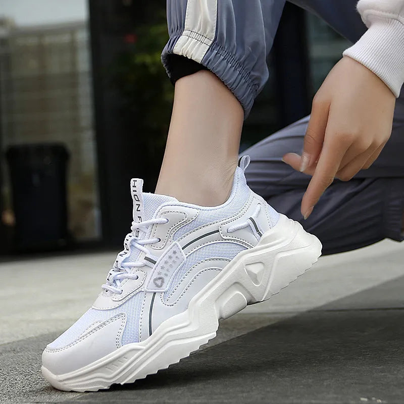 White women's casual mesh sports shoe with thick sole, buckle detail, and round toe.