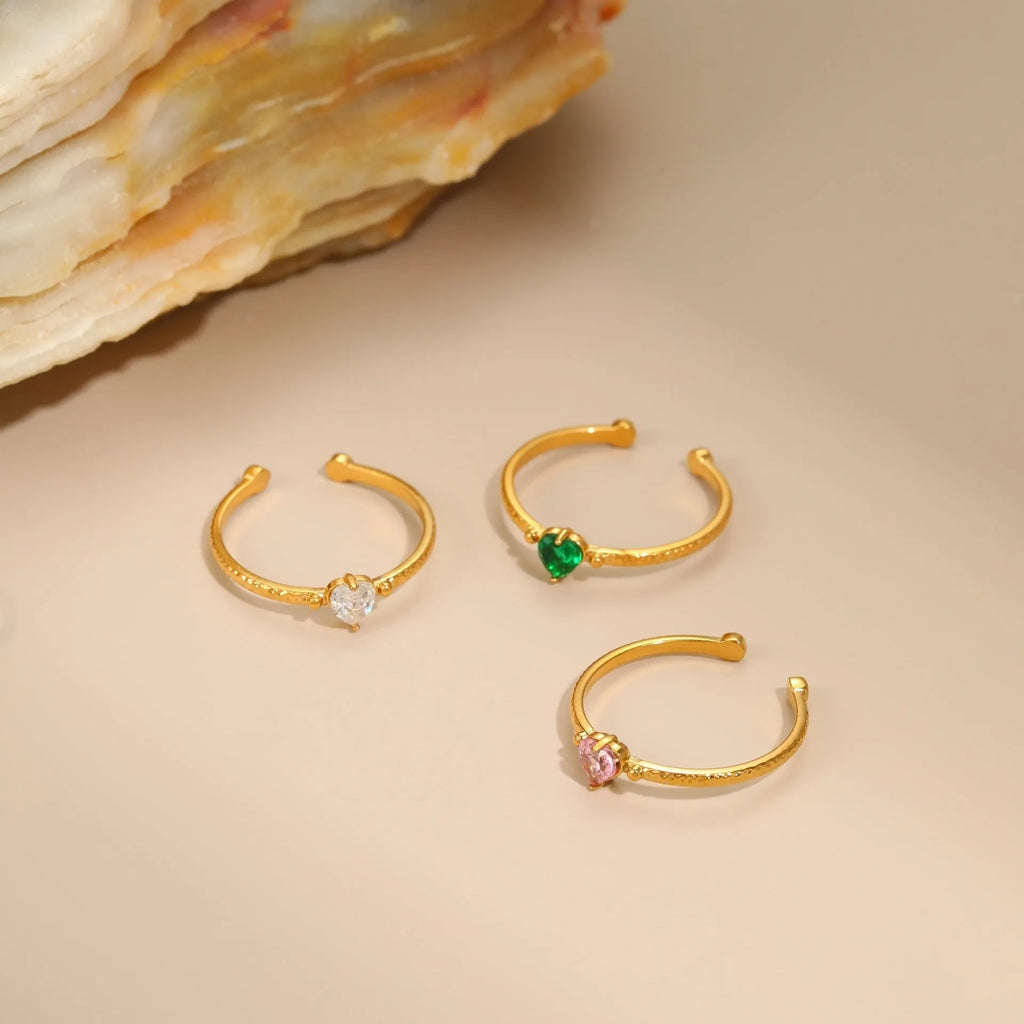 Open-ended stainless steel ring with a heart-shaped green zircon stone inlay on a geometric band.