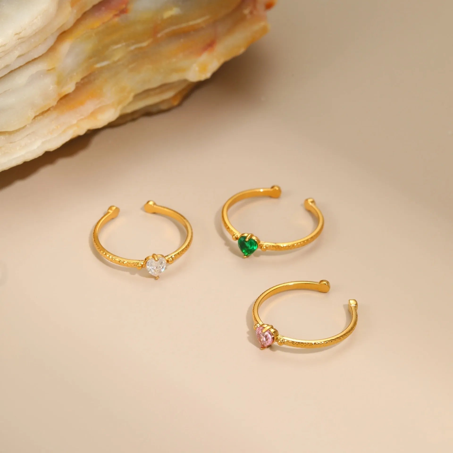 Open-ended stainless steel ring with a heart-shaped green zircon stone inlay on a geometric band.