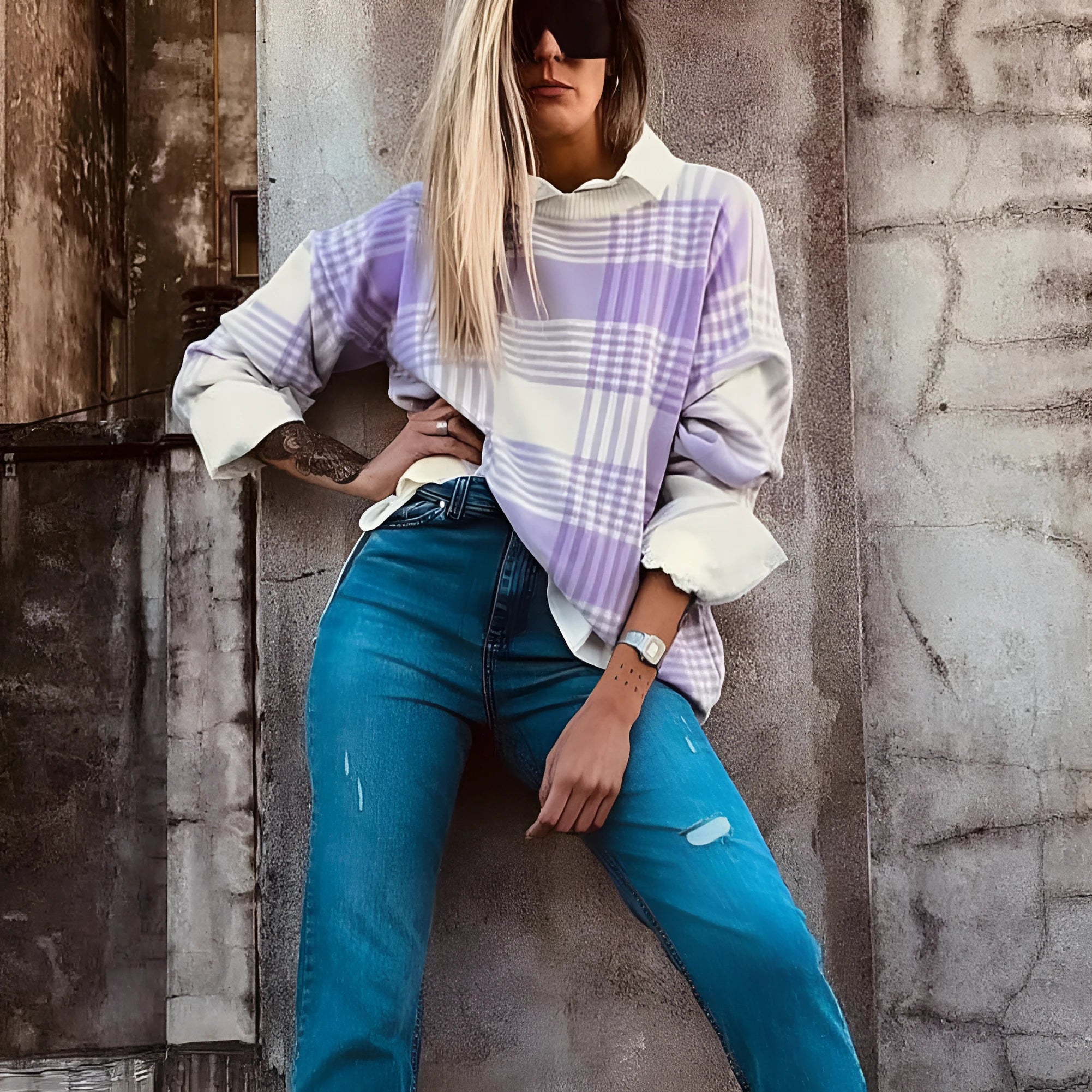 Loose lilac plaid print sweater with long sleeves and ribbed trim on a hanger.