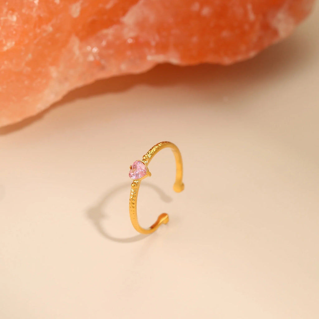 Open-ended stainless steel ring with a heart-shaped green zircon stone inlay on a geometric band.