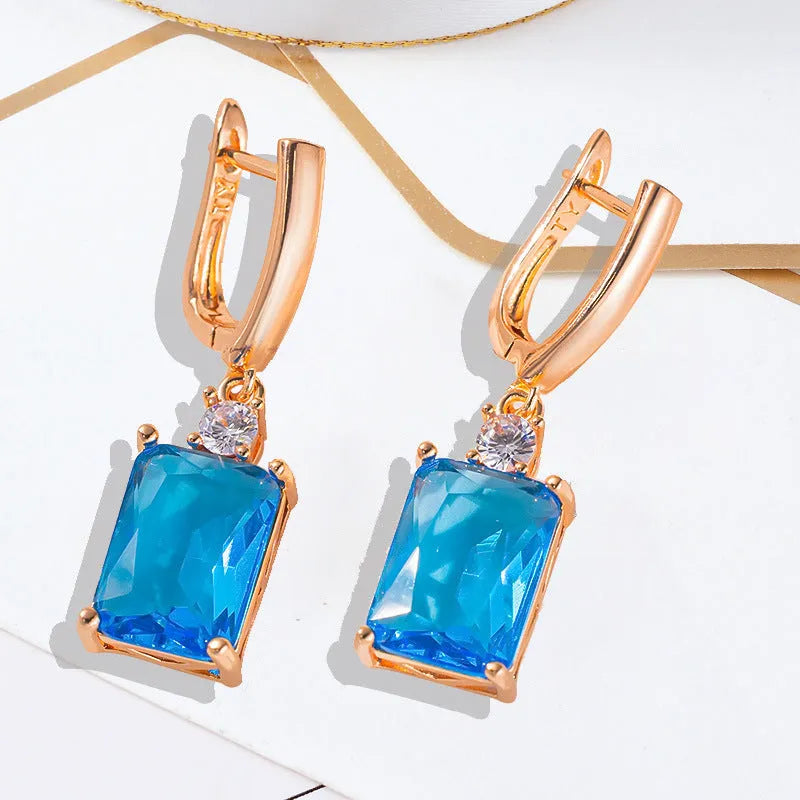 A pair of square geometric earrings with a gold electroplated finish on a copper base.