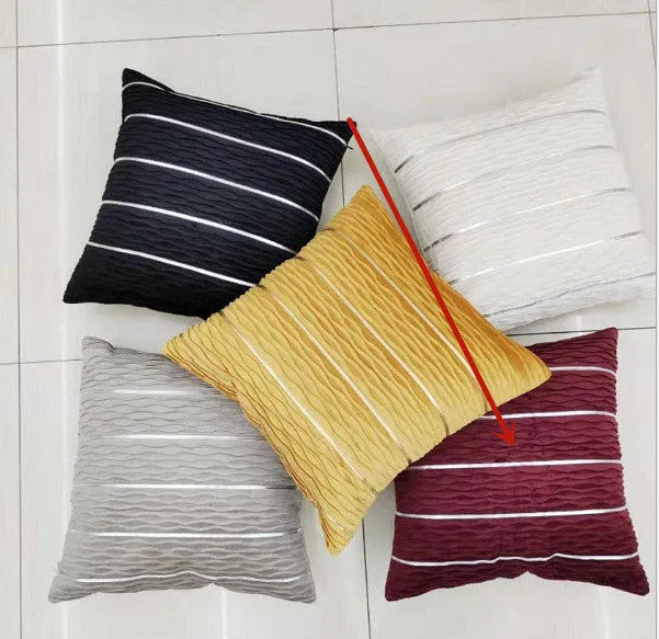 A square plush velvet pillow cover in a striped luxury style, shown in a selection of colours on a sofa.