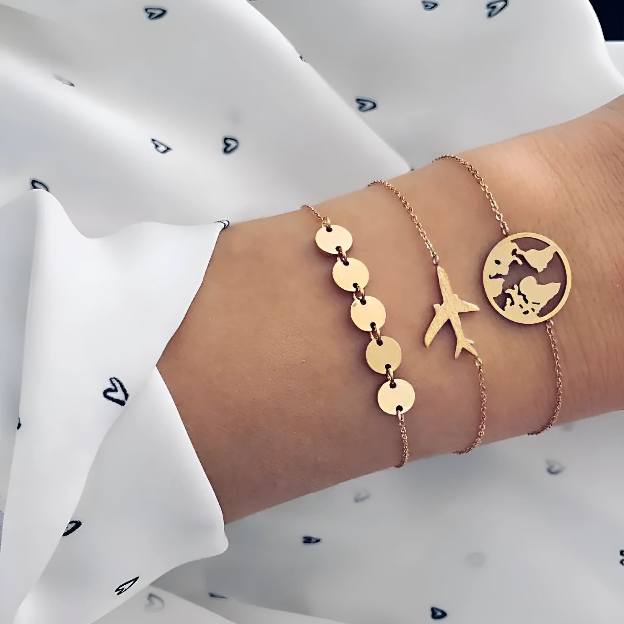 Three matching women's charm bracelets with heart-shaped aviation map designs in electroplated alloy