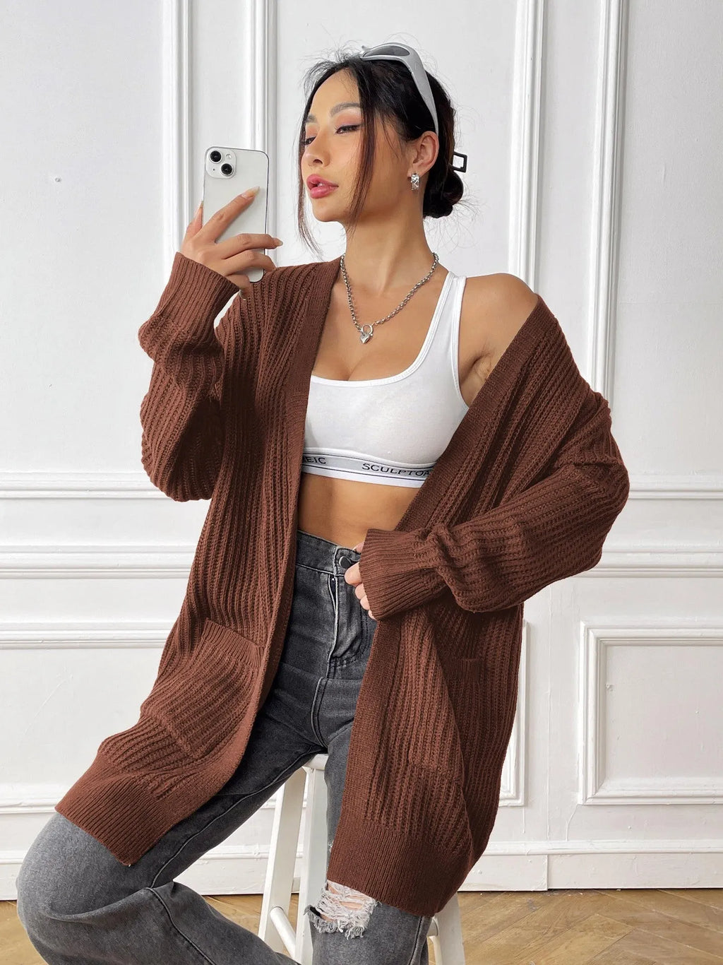 Women's dark green loose-fit cardigan with two front pockets and long sleeves.