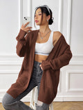 Women's dark green loose-fit cardigan with two front pockets and long sleeves.