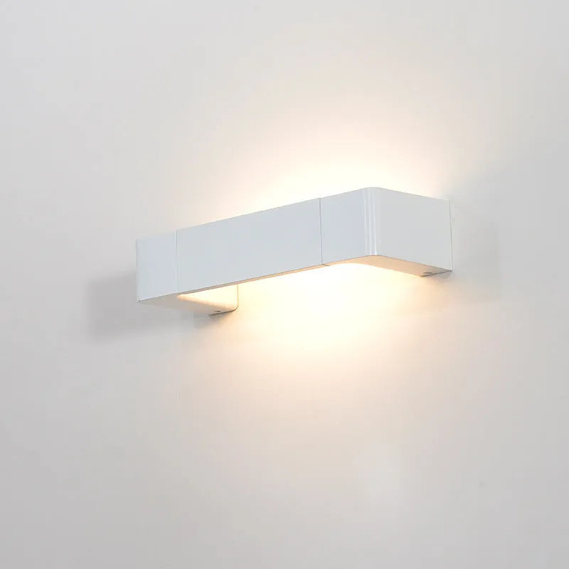 Modern minimalist wall lamp with aluminium shade in gold finish against a white wall