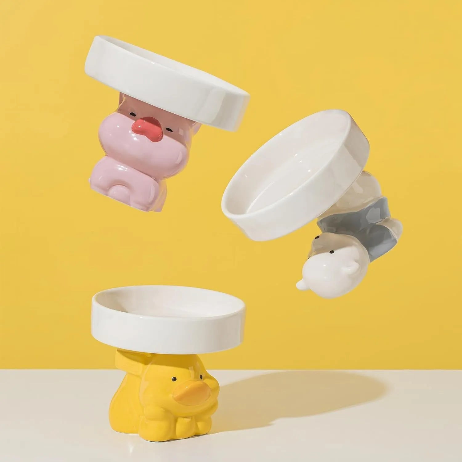 Ceramic elevated cat food bowl with animal theme design in pink, yellow, or white